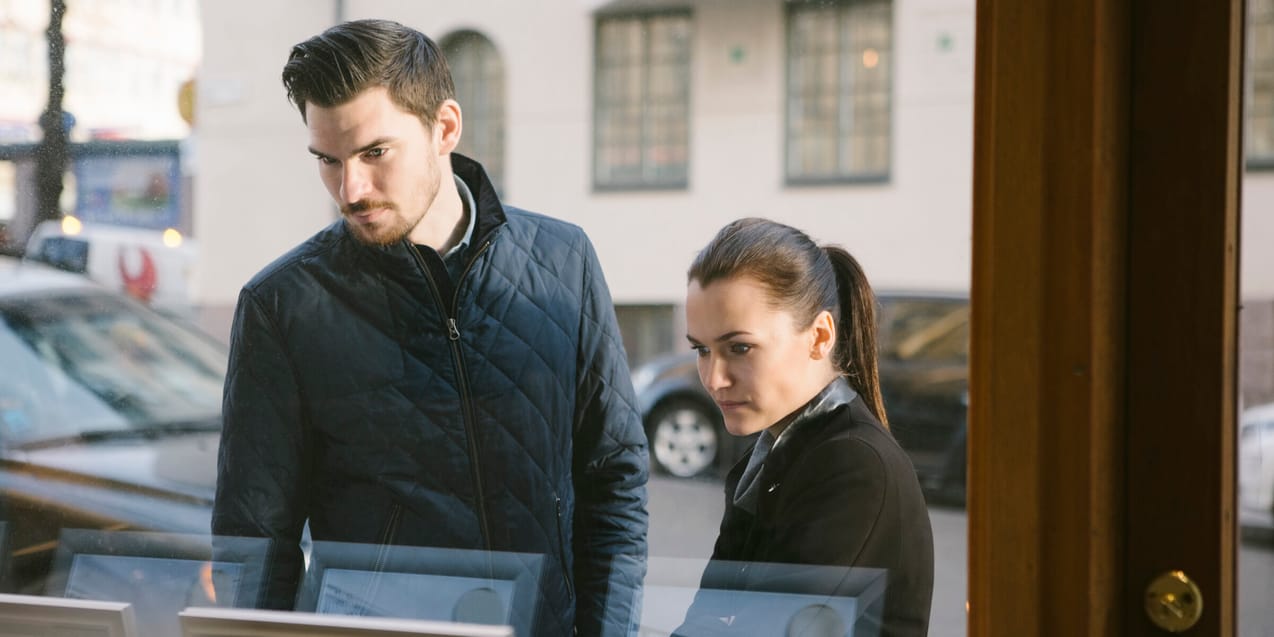 Ett yngre par tittar in i ett skyltfönster