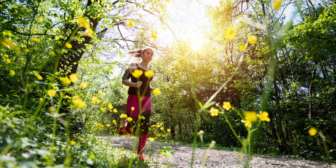 Kvinna joggar i en skog