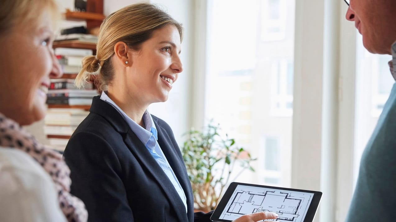 Mäklare som visar en planlösning på en ipad