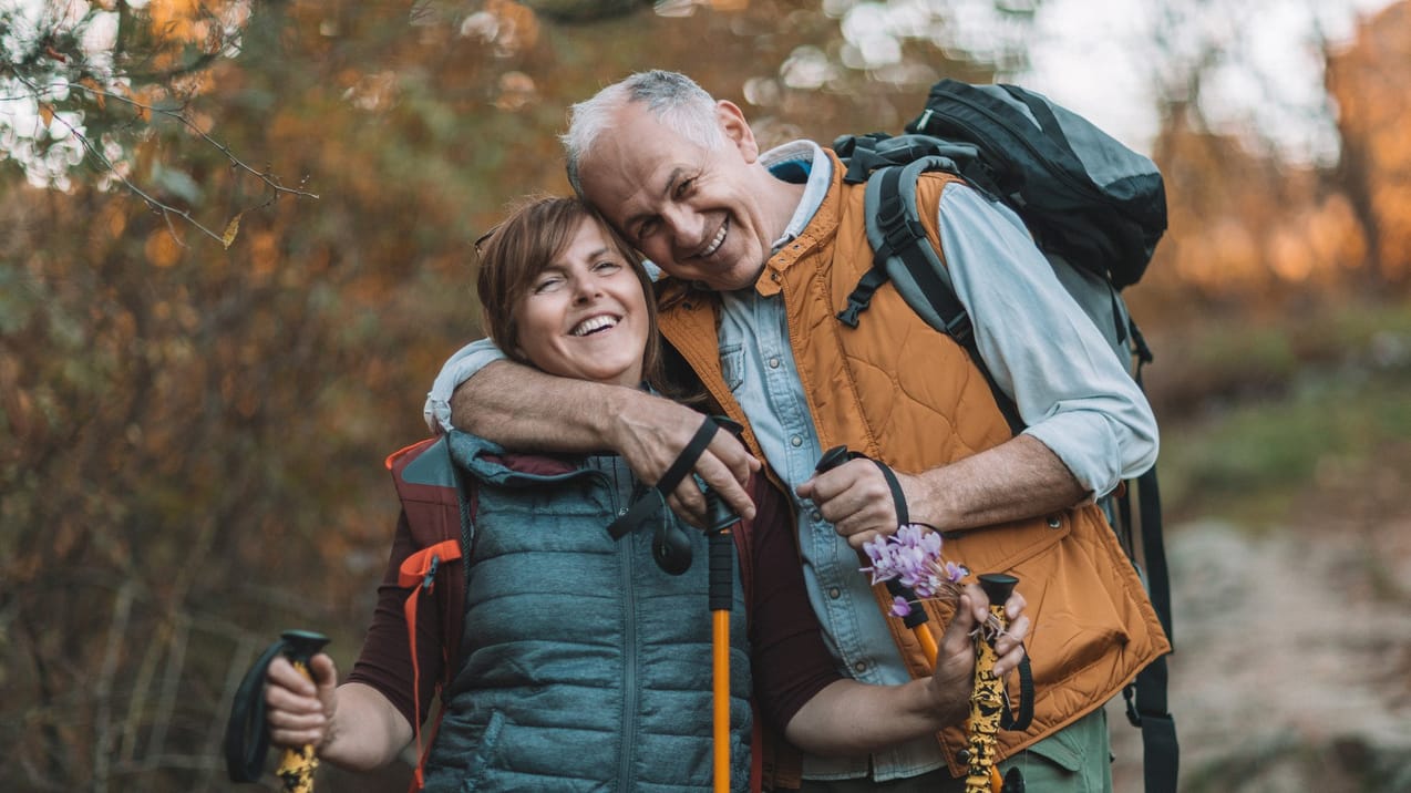 Man och kvinna är ute och vandrar med stavar