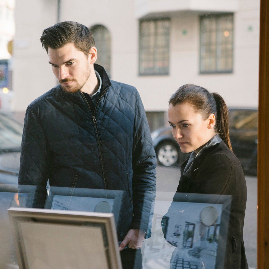 Yngre par kollar i ett skyltfönster