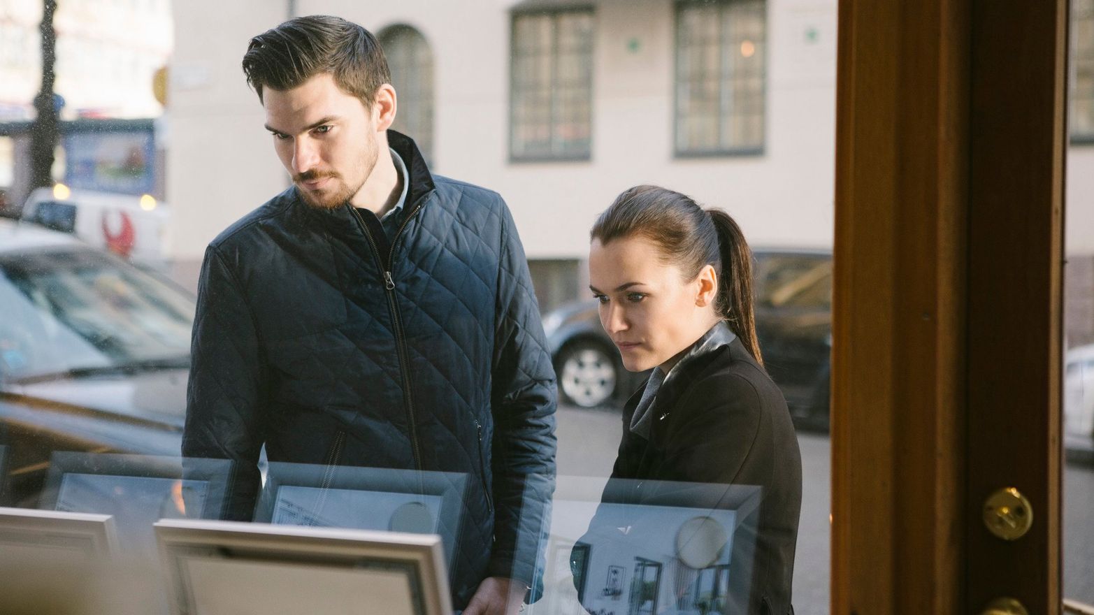 Yngre par kollar i ett skyltfönster