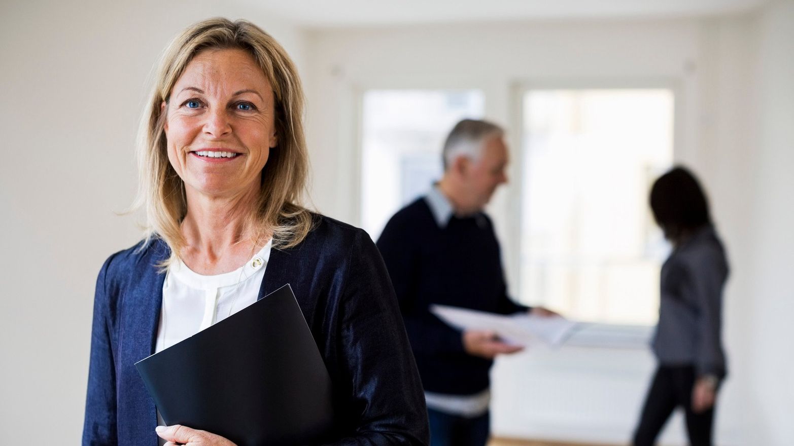 En kvinnlig mäklare som står med ett avtal