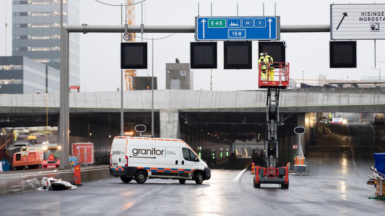 Servicebil och lyftkran framför infarten till en vägtunnel.