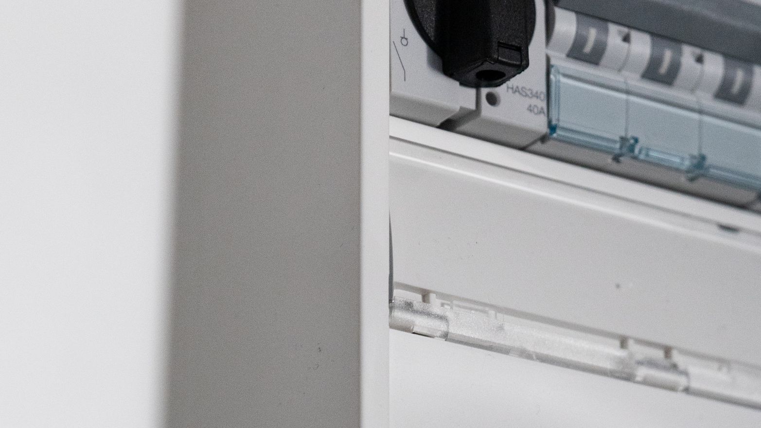 Security elektriker som står vid ett styrskåp och ler