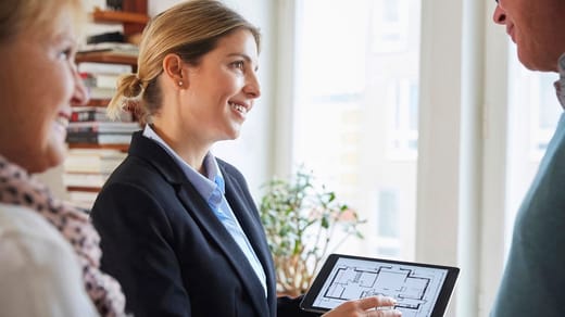 Mäklare som visar en planlösning på en ipad