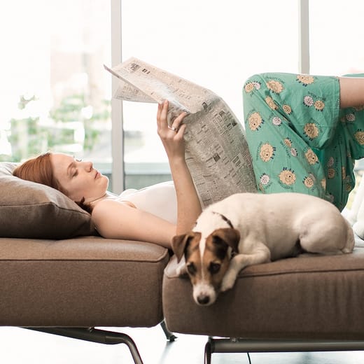 Tjej och hund sitter i sängen