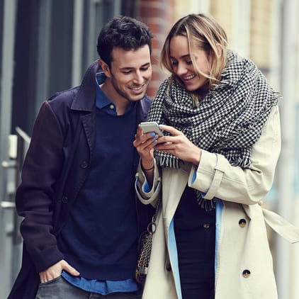Yngre par tittar ner i en telefon