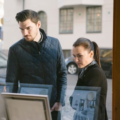 Yngre par tittar in genom ett skyltfönster
