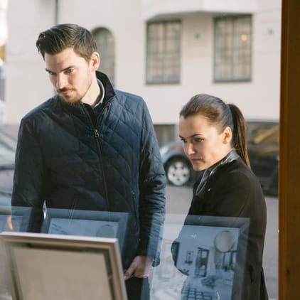 Yngre par tittar in genom ett skyltfönster