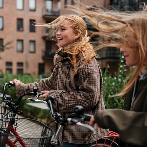 Pojke och flicka springer genom en vattenpöl