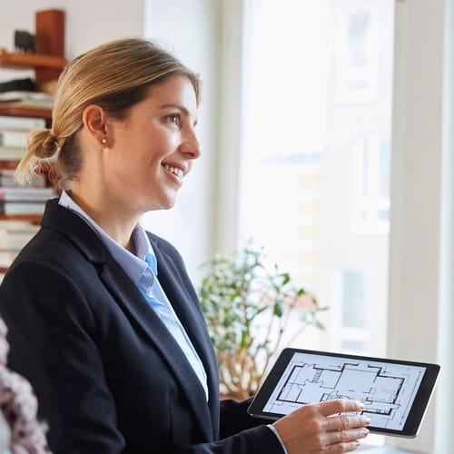 Mäklare som visar en planlösning på en ipad