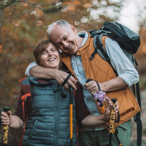 Man och kvinna är ute och vandrar med stavar