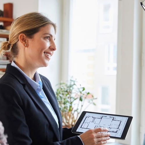 Mäklare som visar en planlösning på en ipad