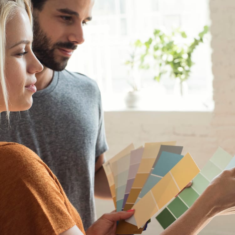 Ett yngre par står och tittar på färgprover