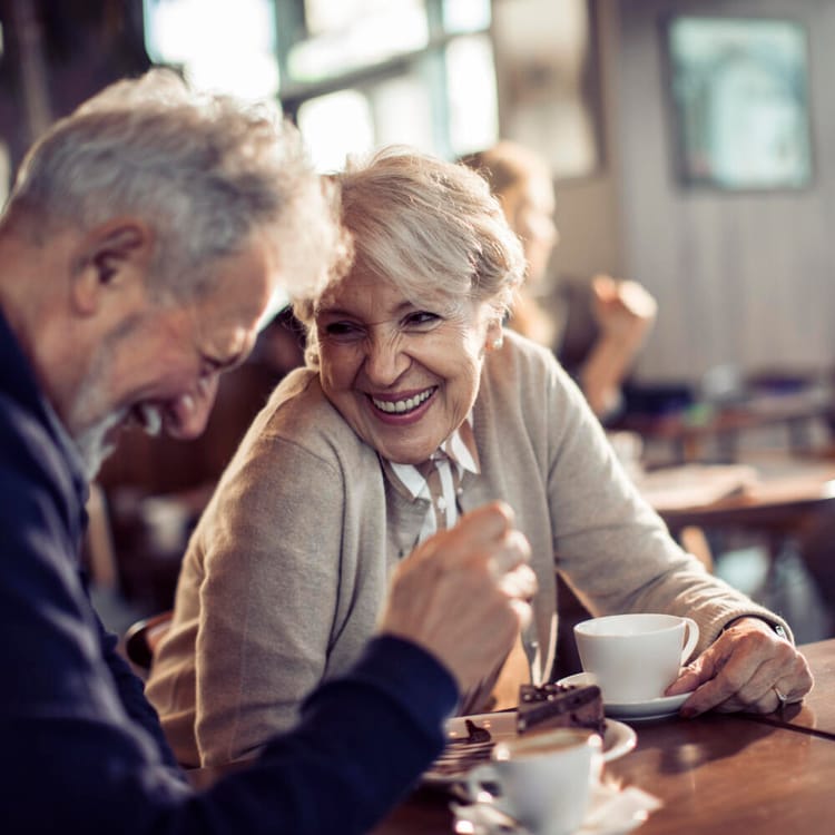Ett äldre par sitter på ett café och har det trevligt